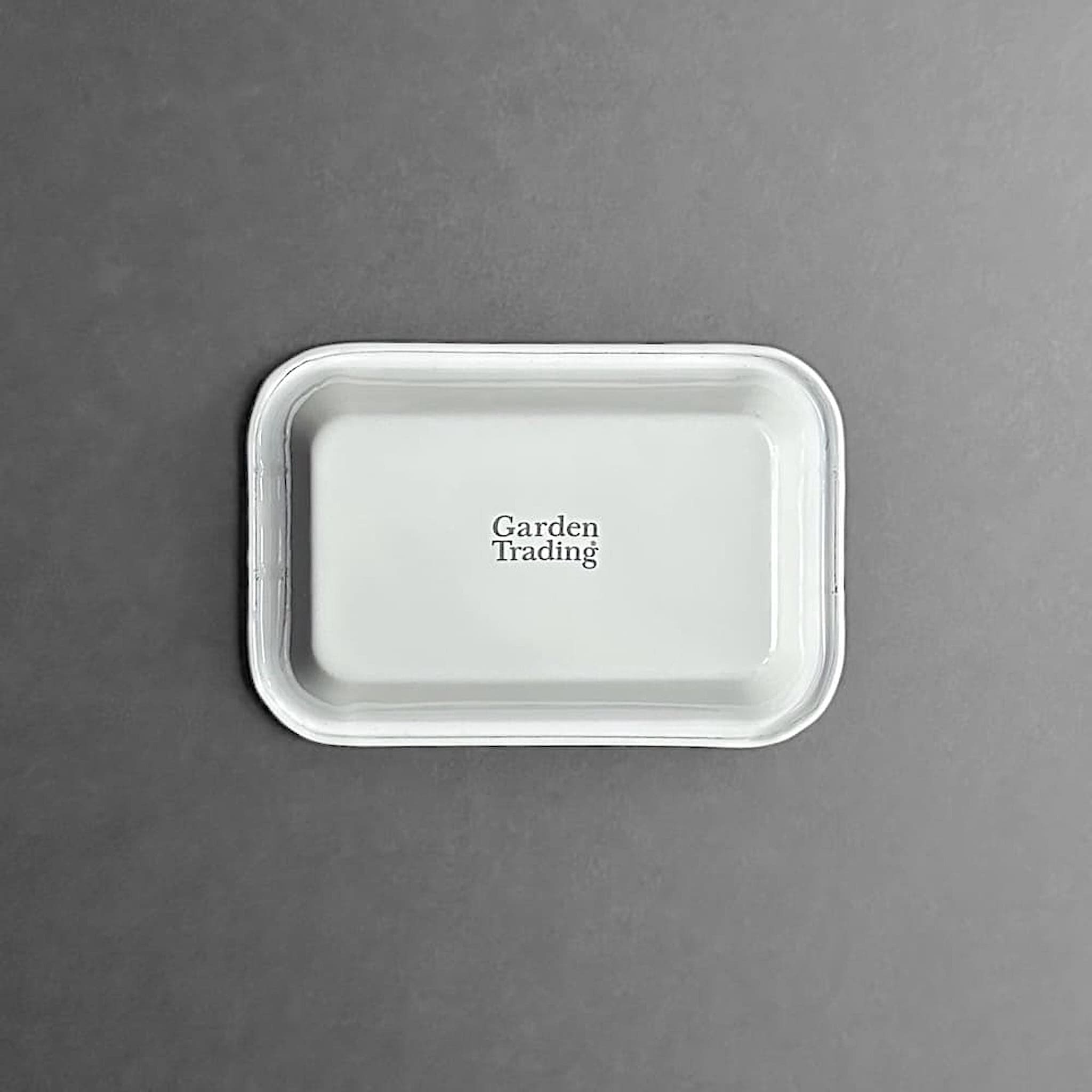 Base view of white enamel soap dish with 'garden trading' brand stamp