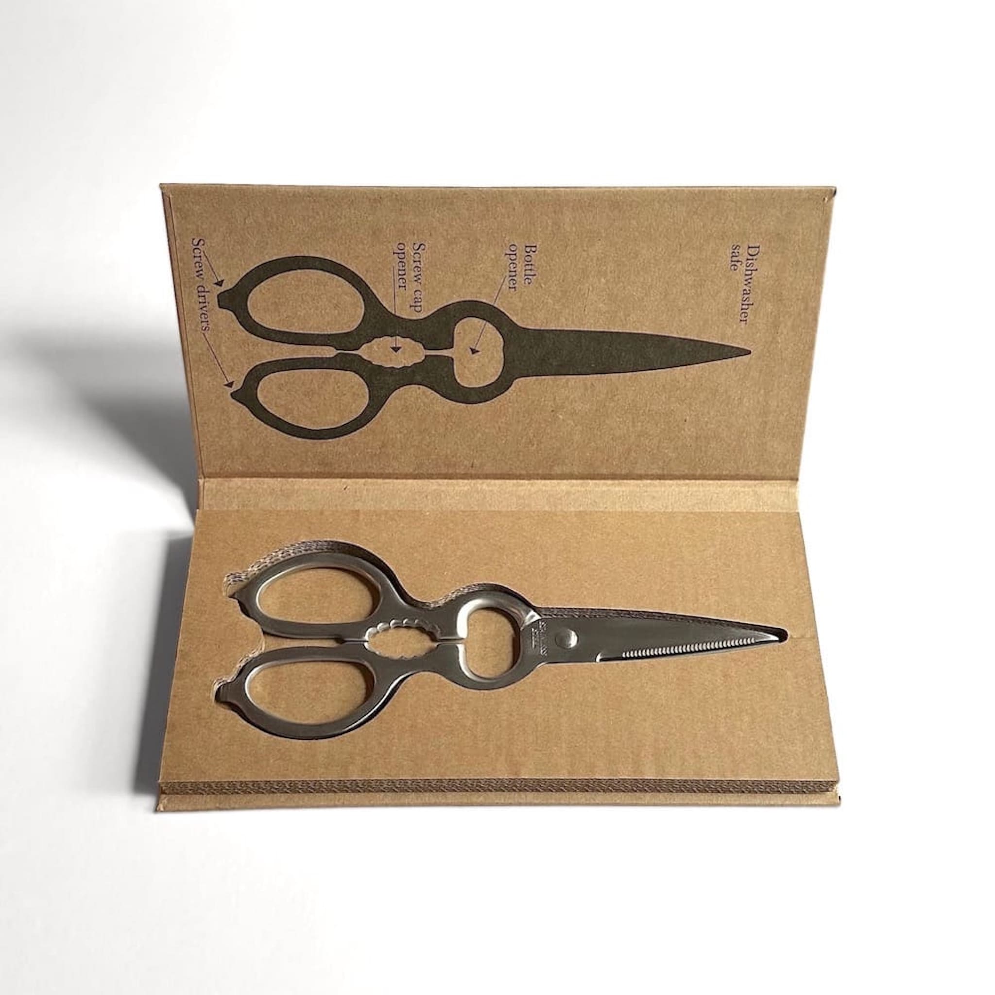 Pair of scissors in cardboard packaging on a white background