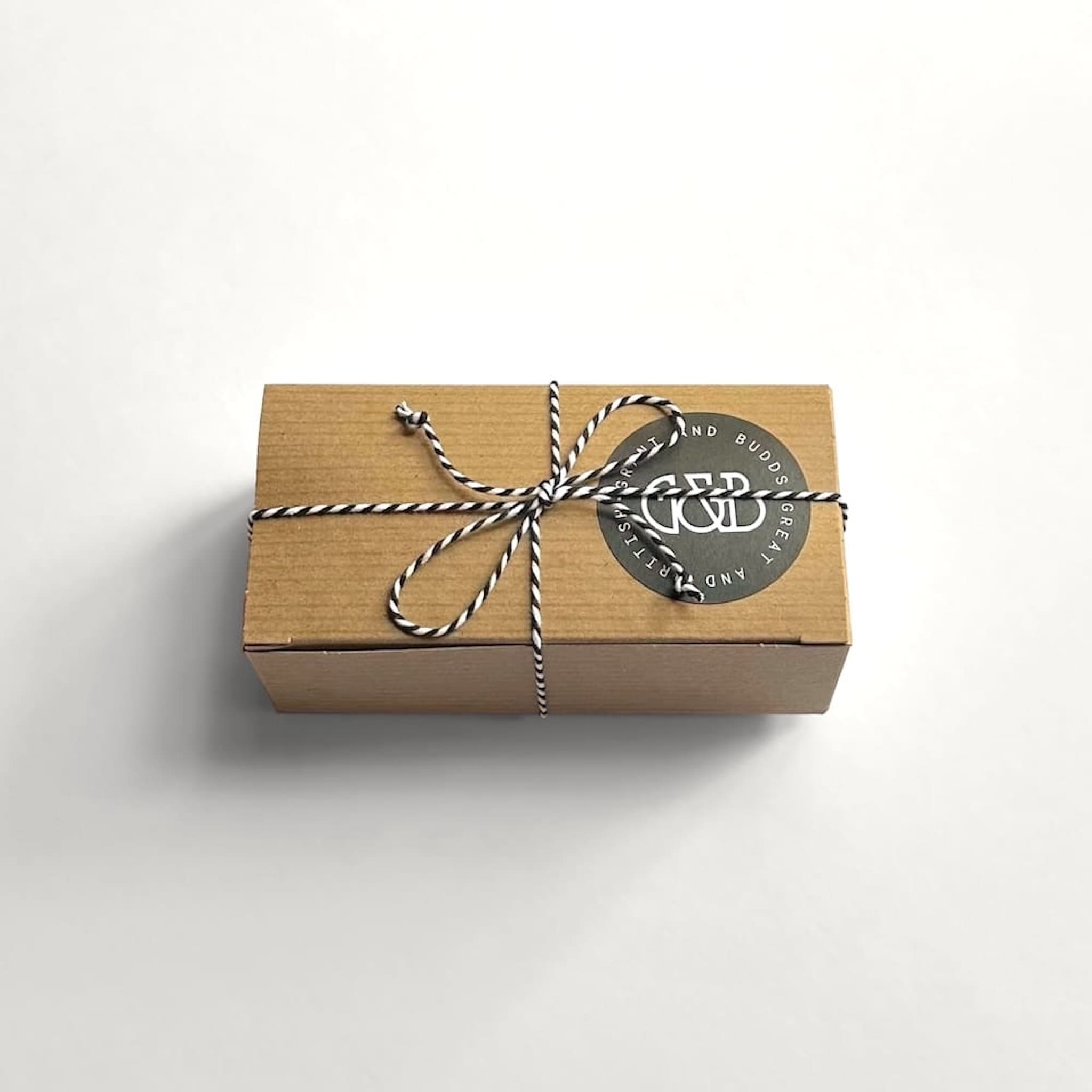 Grant and Budds brown gift box with string and a round label on a white background