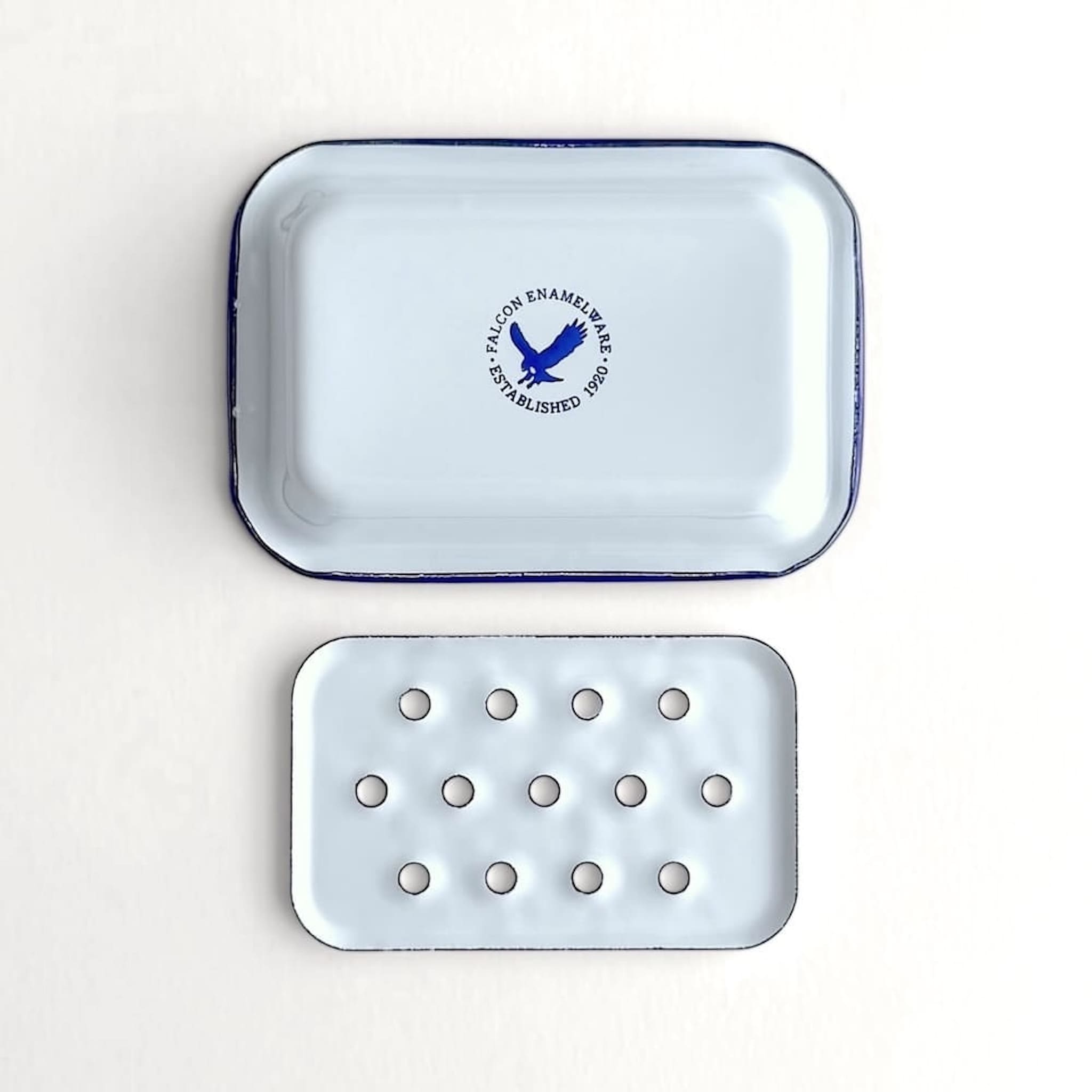 Underside view of a white Falcon enamelware soap dish with authenticity logo stamp