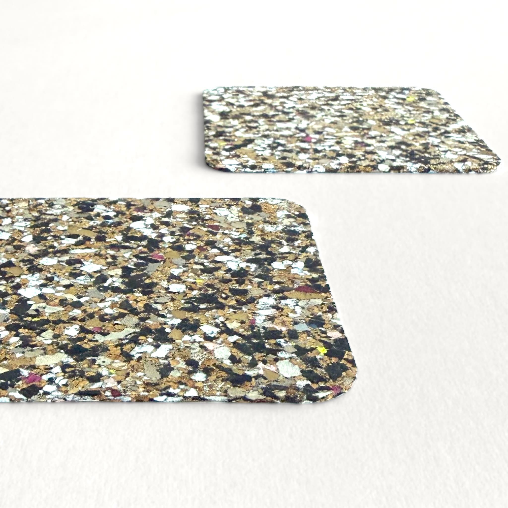 Two speckled patterned coasters on a white background