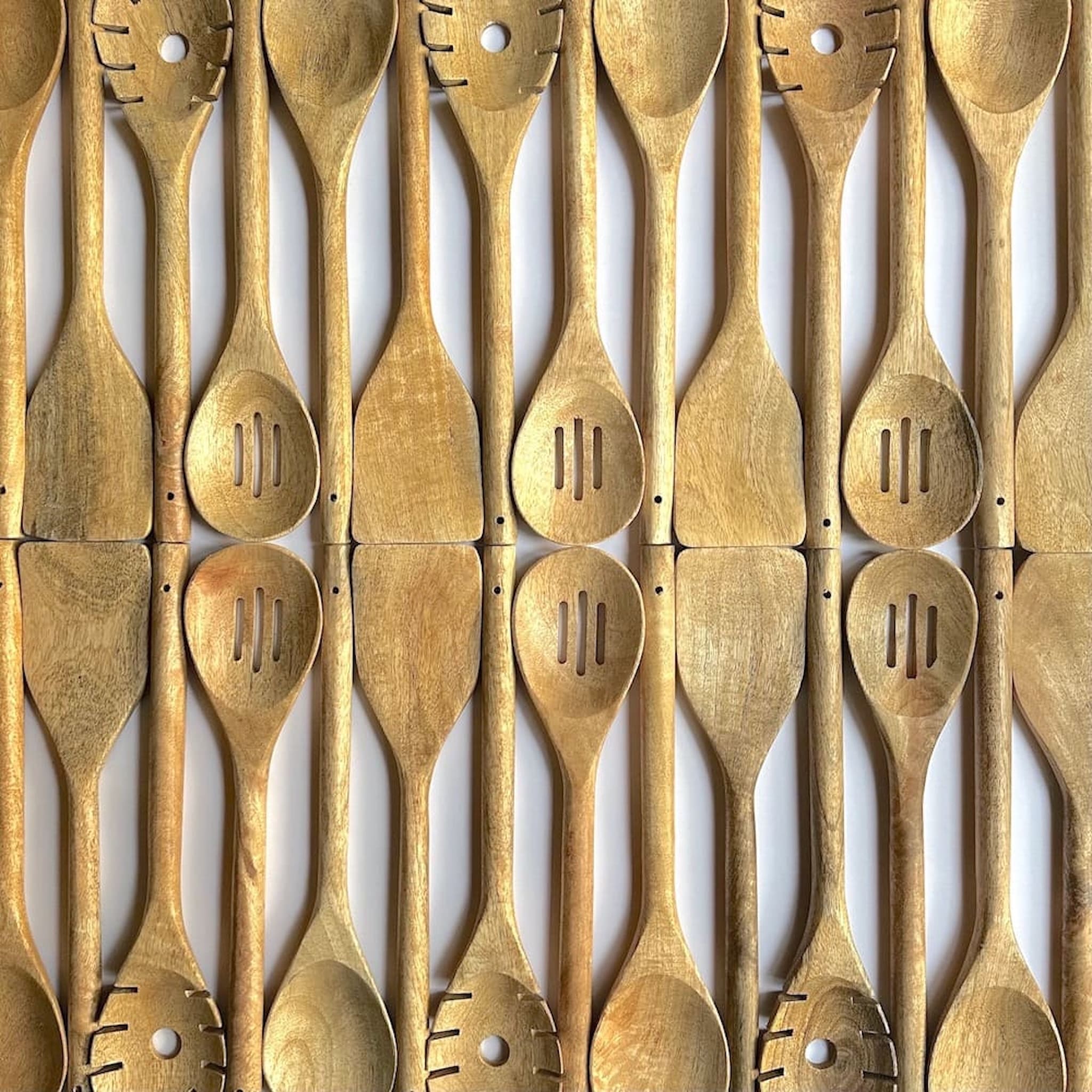 Two rows of mango wood kitchen utensils in varying grain and colour