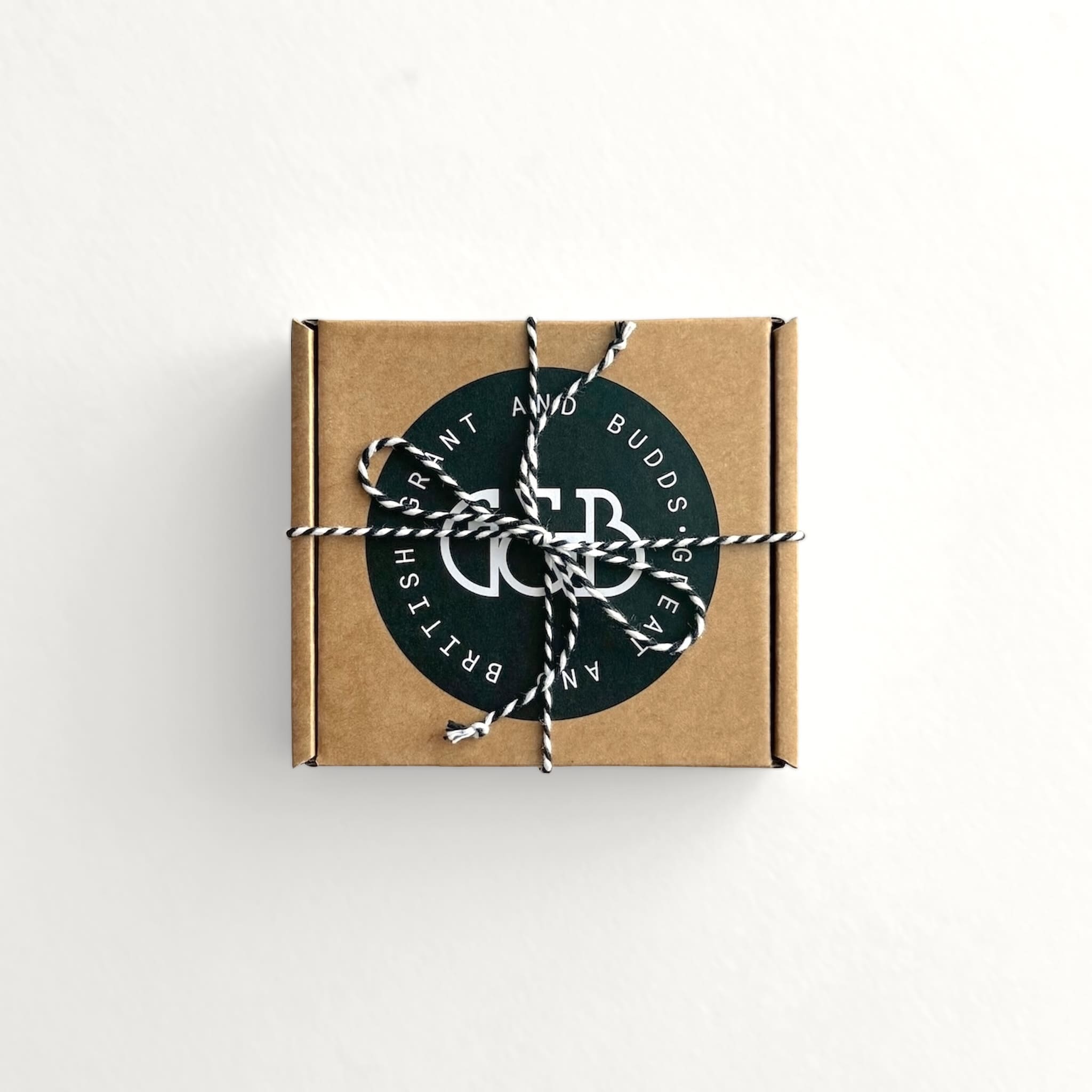 Brown cardboard box with string and a circular label on a white background