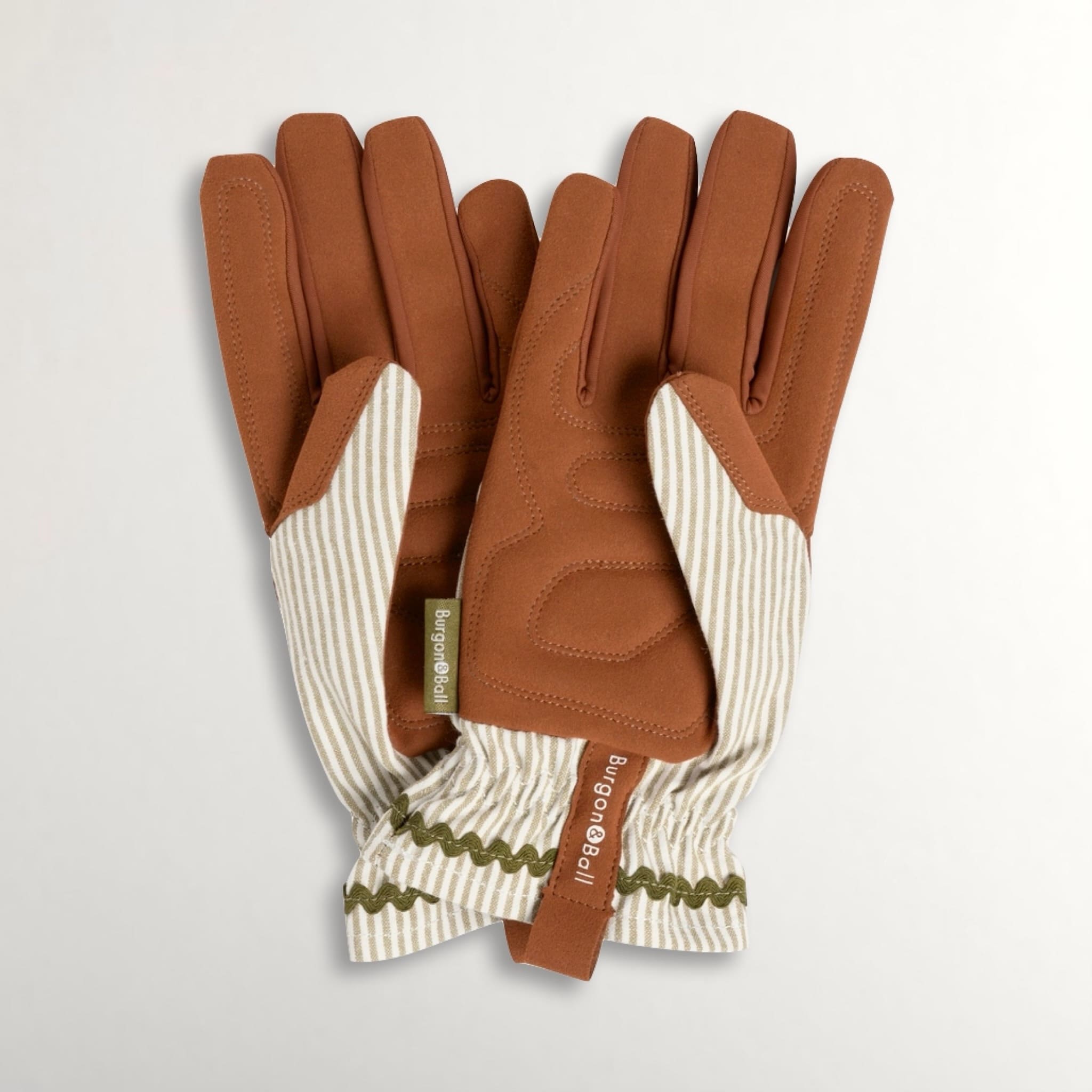 Brown gardening gloves with green and white striped cotton backs on a light grey background.