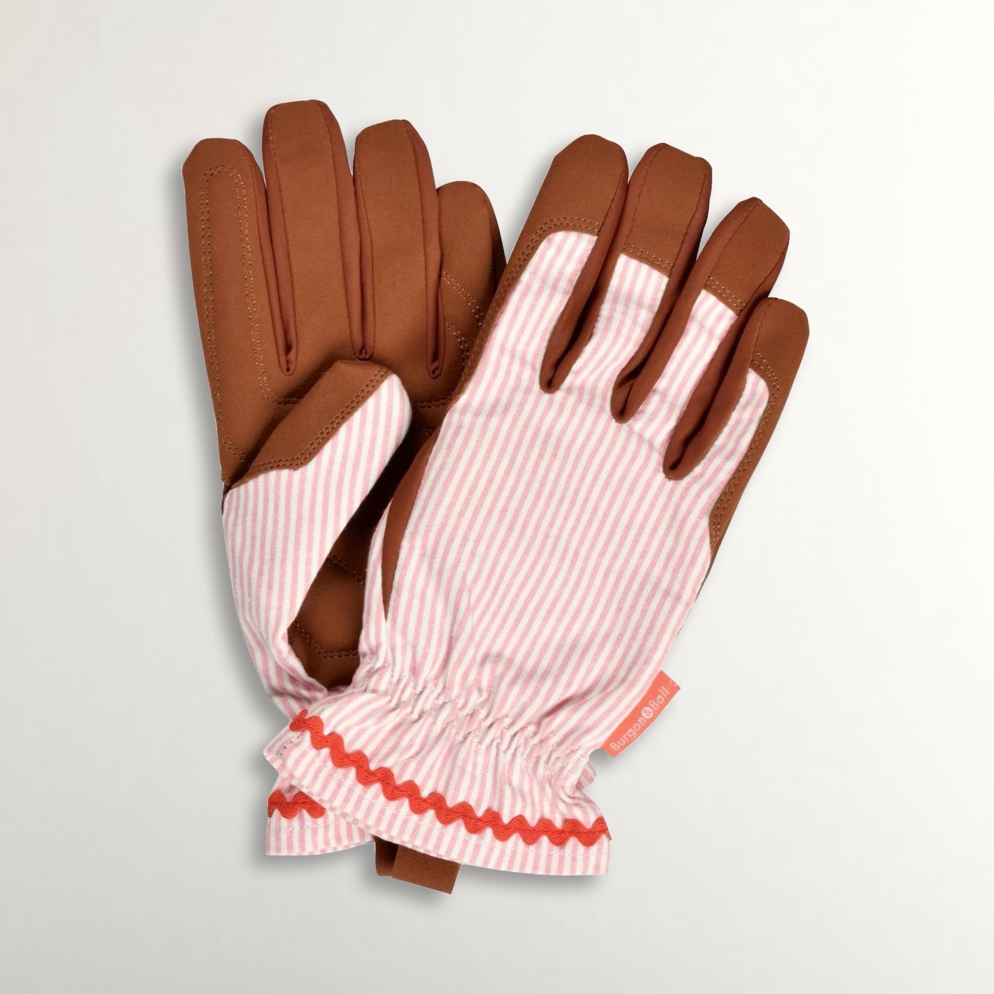 Pair of gardening gloves with faux brown suede and pink striped cotton on a light grey background.