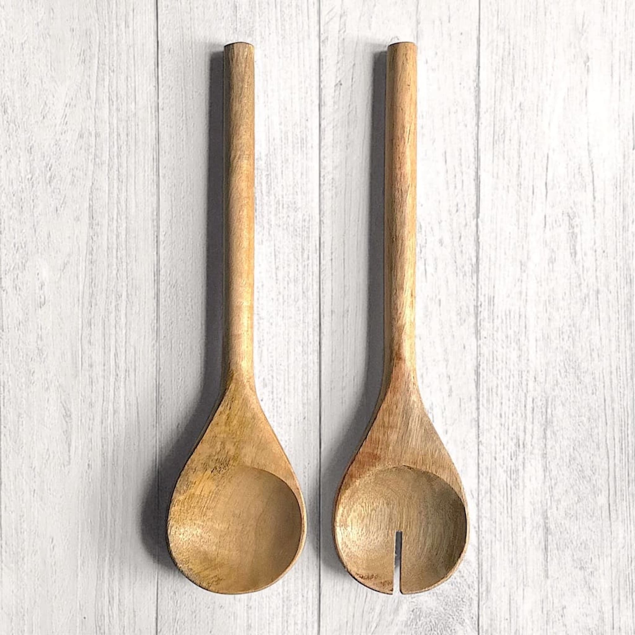 Above view of a pair of mango wood salad servers on a white wooden surface