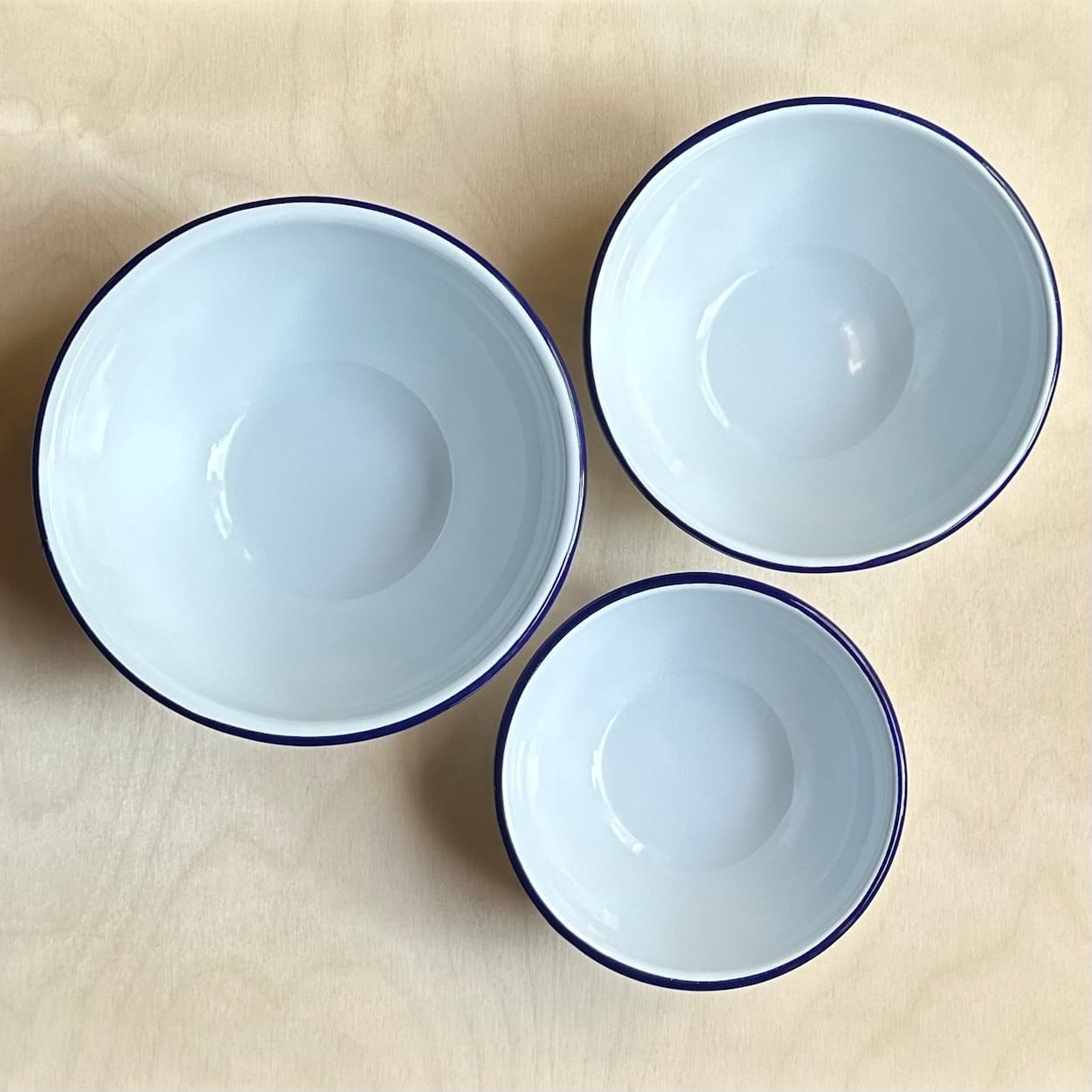 Trio of Blue Rimmed White Enamel Nesting Bowls