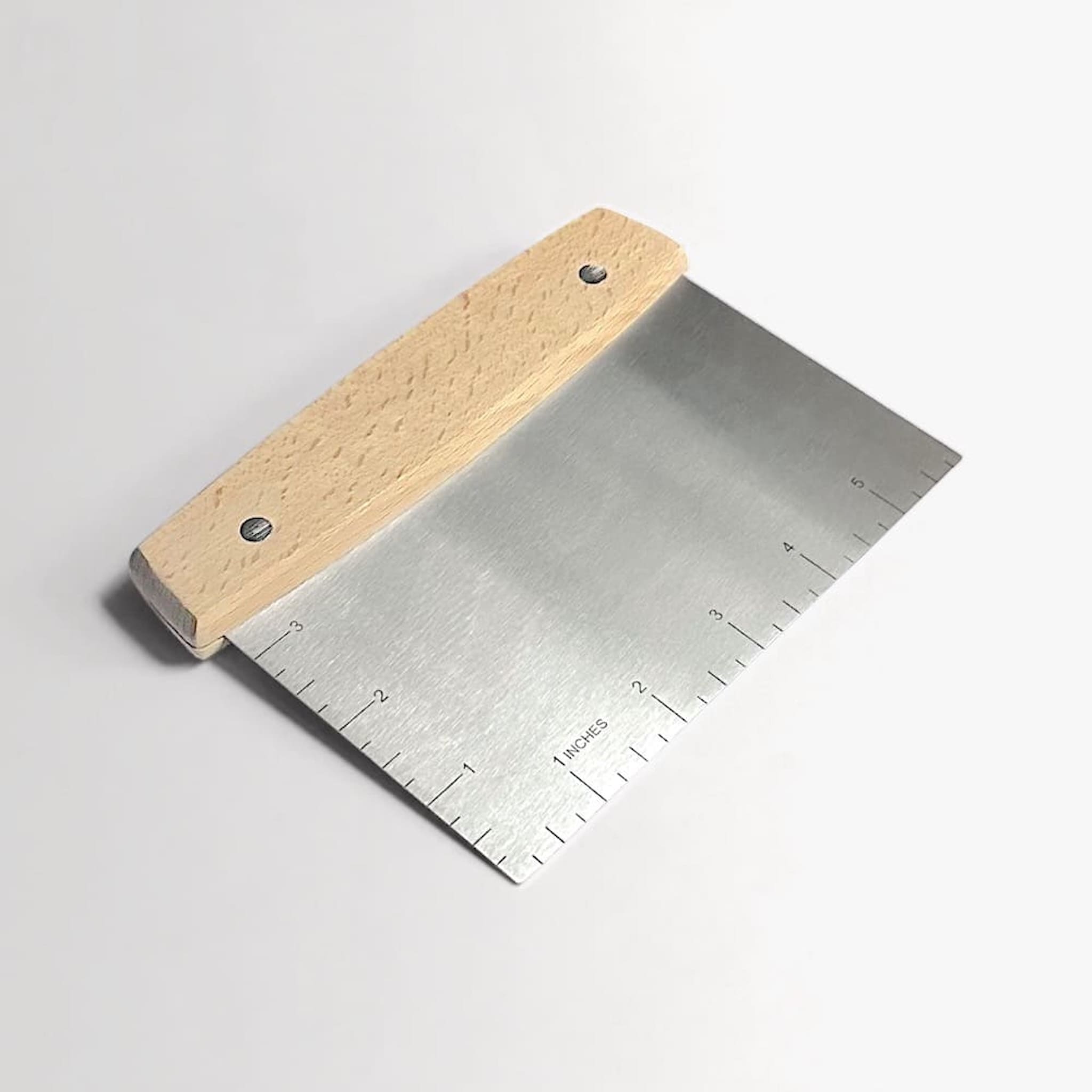Metal bench scraper with wooden handle on a light grey background